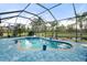 Enclosed pool and spa with tropical landscaping and a serene lake view, ideal for private outdoor enjoyment at 11742 Forest Park Cir, Bradenton, FL 34211