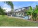 Screened in pool with tropical landscaping and surrounding green lawn, great for outdoor enjoyment at 11742 Forest Park Cir, Bradenton, FL 34211