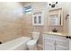 The neutral bathroom features tiled walls and floors, a bath tub, vanity and lots of natural light at 11936 82Nd E St, Parrish, FL 34219