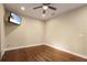 Open bedroom with wood floors, ceiling fan, and a wall-mounted TV at 11936 82Nd E St, Parrish, FL 34219