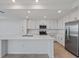 Modern kitchen with white cabinets, stainless steel appliances, and a spacious island at 12180 Wellen Golf St # 302, Venice, FL 34293