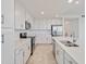 Modern kitchen with stainless steel appliances, white cabinets, and quartz countertops at 12180 Wellen Golf St # 302, Venice, FL 34293