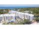 Stunning aerial view of waterfront condo complex with beautiful water views and nearby lush foliage and neighborhood at 1709 N Tamiami Trl # 422, Sarasota, FL 34234