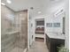 Stylish bathroom featuring a glass shower, stacked washer/dryer, and modern vanity with granite countertop at 1709 N Tamiami Trl # 422, Sarasota, FL 34234