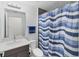 Bathroom with vanity, toilet, and shower featuring blue striped curtain at 1709 N Tamiami Trl # 422, Sarasota, FL 34234