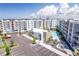 A sunny exterior view showcases the condo buildings, community pool, covered parking, and ample parking spaces at 1709 N Tamiami Trl # 422, Sarasota, FL 34234