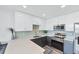 Well-lit kitchen with stainless steel appliances, light quartz countertops, sleek cabinets, and tile backsplash at 1709 N Tamiami Trl # 422, Sarasota, FL 34234
