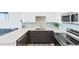 Contemporary kitchen features quartz countertops, stainless steel appliances, tile backsplash, and gray cabinets at 1709 N Tamiami Trl # 422, Sarasota, FL 34234