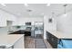 Modern kitchen with stainless steel appliances, white cabinets, and blue backsplash at 1709 N Tamiami Trl # 422, Sarasota, FL 34234