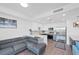 Open living area with modern kitchen, stainless steel appliances, gray sectional couch, and beach themed art at 1709 N Tamiami Trl # 422, Sarasota, FL 34234