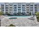 Community pool and jacuzzi with lounge chairs, umbrellas, and well-maintained deck at 1709 N Tamiami Trl # 422, Sarasota, FL 34234