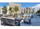Relaxing outdoor lounge area with a modern fireplace, comfortable seating, and a view of the pool and surrounding buildings at 1709 N Tamiami Trl # 422, Sarasota, FL 34234