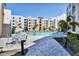 Inviting pool area with plenty of seating, lush landscaping, and a serene atmosphere with lovely condos in the background at 1709 N Tamiami Trl # 422, Sarasota, FL 34234