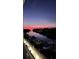 Beautiful waterfront view featuring a canal with boats docked along the illuminated boardwalk at sunset at 1709 N Tamiami Trl # 422, Sarasota, FL 34234