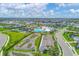 A bird's-eye view of the community's amenities including pool, clubhouse, pump track, parking, and residential area at 17842 Cherished Loop, Bradenton, FL 34211