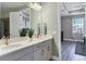 A bright bathroom featuring double sinks, modern fixtures, and a view into the bedroom at 17842 Cherished Loop, Bradenton, FL 34211