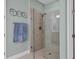 Modern bathroom featuring a glass-enclosed shower with tile surround and a towel rack with decorative metal art at 17842 Cherished Loop, Bradenton, FL 34211