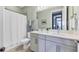 Well-lit bathroom with double vanity sinks, a large mirror, and a shower featuring a white curtain at 17842 Cherished Loop, Bradenton, FL 34211