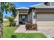 Inviting home exterior featuring a paved walkway, lush landscaping, and a two-car garage at 17842 Cherished Loop, Bradenton, FL 34211