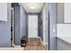 Hallway with hardwood floors, neutral paint, and a bench and shoe rack, with the front door at the end at 17842 Cherished Loop, Bradenton, FL 34211