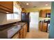 Kitchen area showcasing stainless steel appliances, black countertops, wood cabinetry and tile floors at 221 Laurel E Rd, Nokomis, FL 34275