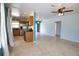 Bright living room adjacent to the kitchen, featuring tile floors, a ceiling fan and backyard views at 221 Laurel E Rd, Nokomis, FL 34275