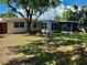 Spacious backyard featuring a screened-in lanai and mature trees providing ample shade at 2412 Grove St, Sarasota, FL 34239