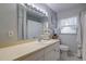 Bright bathroom features a neutral vanity, a large mirror with vanity lighting, and updated decor at 2412 Grove St, Sarasota, FL 34239