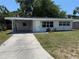 Charming single-story home featuring a covered carport and a well-maintained front yard at 2412 Grove St, Sarasota, FL 34239