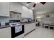 Efficient kitchen design with white cabinets, granite countertops, and a view into the dining area at 2412 Grove St, Sarasota, FL 34239