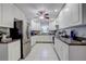 Well-lit kitchen featuring white cabinetry, stainless steel refrigerator, and granite countertops at 2412 Grove St, Sarasota, FL 34239