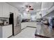 Well-lit kitchen featuring white cabinetry, stainless steel refrigerator, and granite countertops at 2412 Grove St, Sarasota, FL 34239