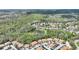 Aerial view of the homes located near a pond and surrounded by a tree-lined landscape at 27621 Kirkwood Cir, Wesley Chapel, FL 33544