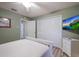 Comfortable bedroom features include a closet, wall mounted television, and neutral tones throughout the space at 313 Magnolia Ave, Anna Maria, FL 34216