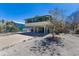 Stilt home featuring a large driveway and an enclosed lower level providing ample parking and storage space at 313 Magnolia Ave, Anna Maria, FL 34216