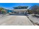 Stilt home featuring a large driveway and an enclosed lower level providing ample parking and storage space at 313 Magnolia Ave, Anna Maria, FL 34216