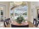 Bright breakfast nook with granite table offering scenic views of the pool and lake at 3218 45Th E Way, Bradenton, FL 34203