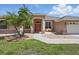 Charming single-story home featuring a manicured lawn, stone accents, covered entry, and bench at 3218 45Th E Way, Bradenton, FL 34203