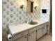 Bright bathroom featuring a vanity with ample counter space, decorative wallpaper, and modern lighting fixtures at 3232 Ash Ter, Sarasota, FL 34237