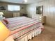 Bright bedroom features a striped bedspread, light walls, ceiling fan, and matching dressers with ample storage at 3232 Ash Ter, Sarasota, FL 34237