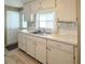 Kitchen has white cabinets, laminate countertops, and stainless steel sink at 3232 Ash Ter, Sarasota, FL 34237