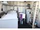 Utility room featuring washer, dryer, sink, and water heater with white shelving and plumbing at 3232 Ash Ter, Sarasota, FL 34237