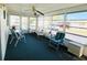 Bright sunroom features ample seating and plenty of windows overlooking community street view at 3232 Ash Ter, Sarasota, FL 34237