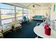 Bright sunroom features ample seating, fan, and plenty of windows with relaxing community views at 3232 Ash Ter, Sarasota, FL 34237