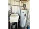 Utility area with sink, hot water heater, and storage providing essential home functionality at 3232 Ash Ter, Sarasota, FL 34237