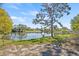 Scenic lake view from the backyard, with a charming tree, lush grass and fenced yard at 3503 67Th W St, Bradenton, FL 34209