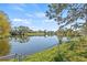 Backyard featuring a serene lake view, green foliage and reflective water under a blue sky at 3503 67Th W St, Bradenton, FL 34209