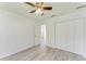 Bedroom with light grey wood-look floors, ceiling fan, large closet and door that leads to the bathroom at 357 Woodvale Dr, Venice, FL 34293