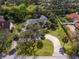 Wide aerial view of the house surrounded by lush trees and large green lawn at 3648 Beneva Oaks Blvd, Sarasota, FL 34238