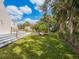 Spacious backyard with a large lawn, mature trees, and partial view of the home's deck at 3648 Beneva Oaks Blvd, Sarasota, FL 34238